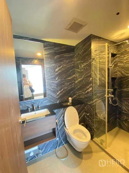 Condominium for rent - Contemporary bathroom with marble‑look walls, glass shower enclosure and vanity.