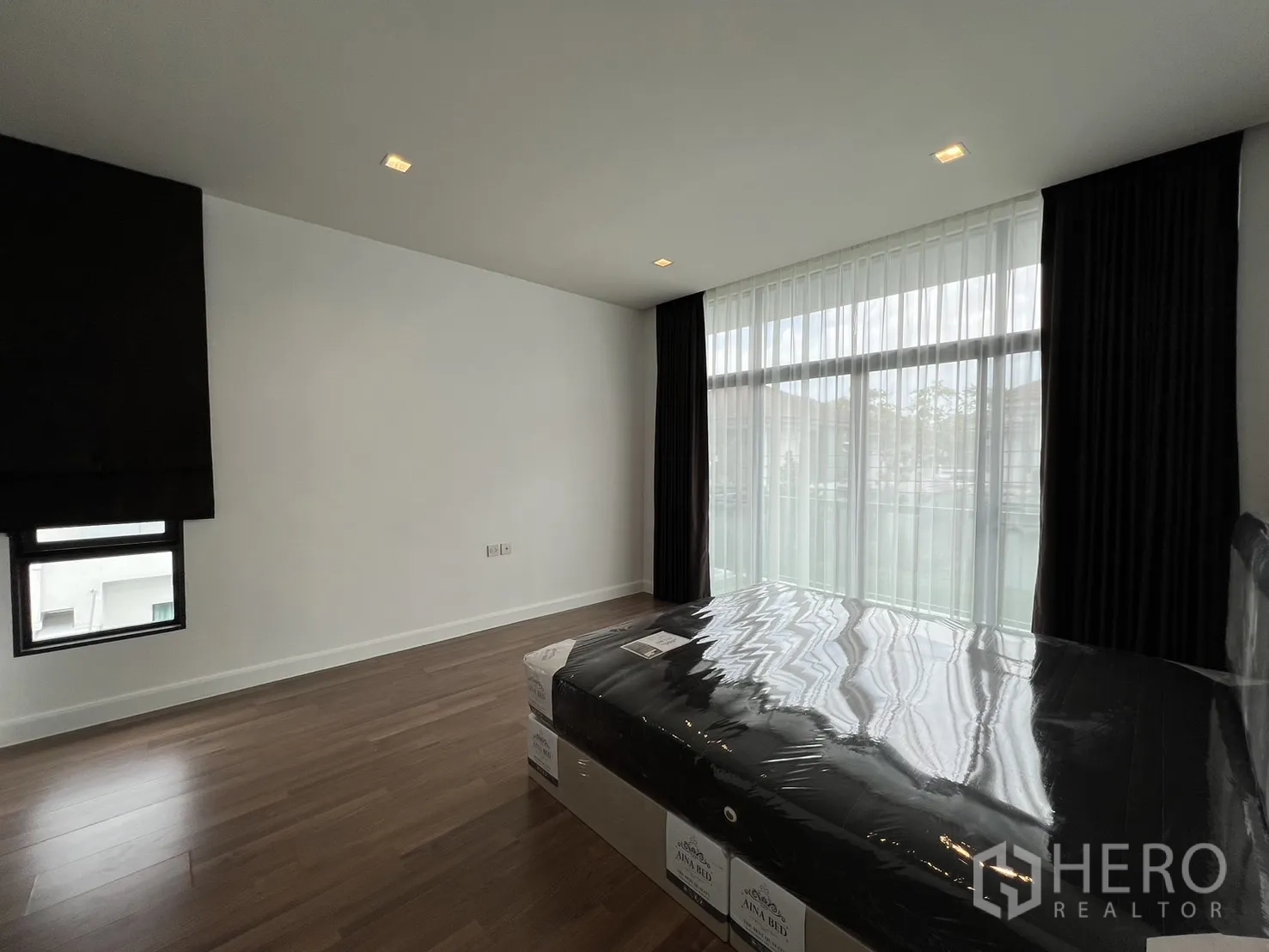 独立式住宅 出租在Bang Kapi, Bangkok - 主卧另一角度，面向阳台窗与木地板。