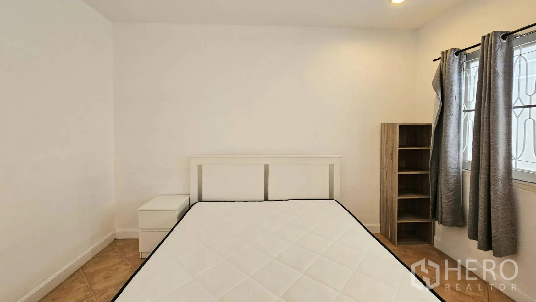 Detached House for rent in Saphan Sung, Bangkok - Bedroom corner with headboard, bedside table, and open shelving by curtained window.