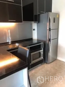 คอนโด ให้เช่าหรือขายในKhlong Toei, Bangkok - ครัวทันสมัย เคาน์เตอร์สีดำ ตู้เย็นสแตนเลสและไมโครเวฟ