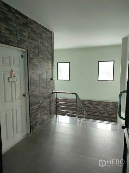 工厂 出租在Ban Phaeo, Samut Sakhon - 二层楼梯平台，不锈钢栏杆与瓷砖特色墙。