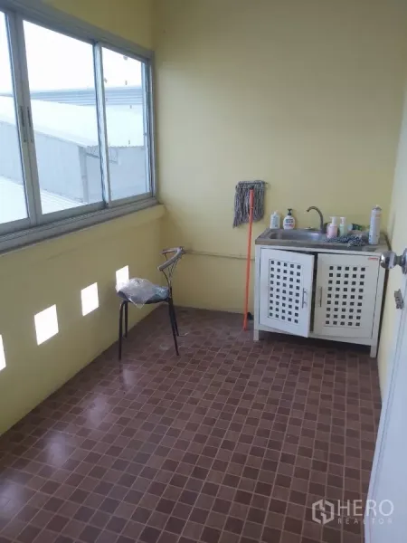 Warehouse for rent in Krathum Baen, Samut Sakhon - Compact utility area with sink, cleaning supplies and sliding windows.