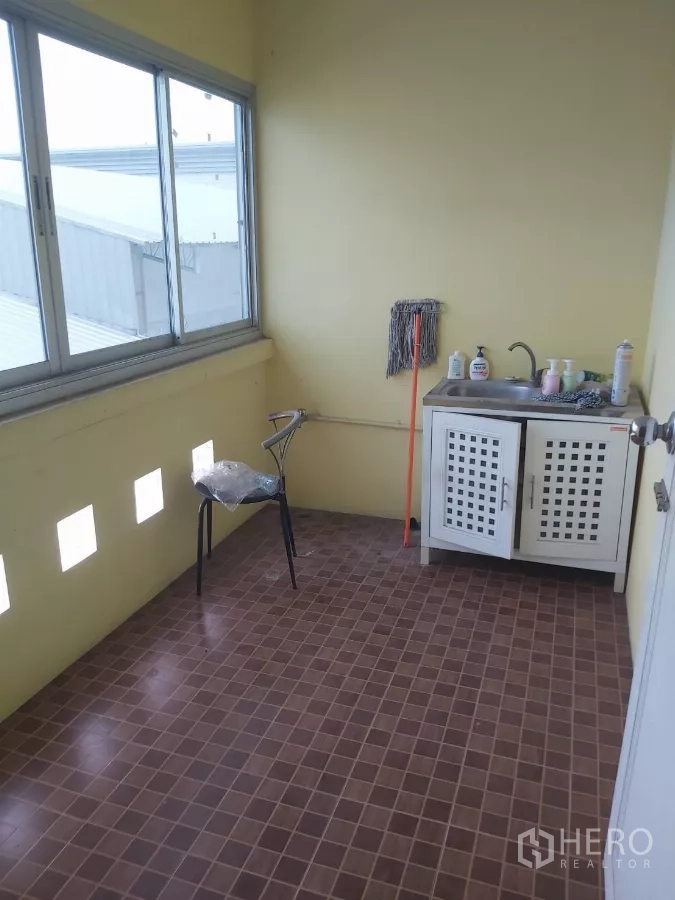 Warehouse for rent in Krathum Baen, Samut Sakhon - Compact utility area with sink, cleaning supplies and sliding windows.
