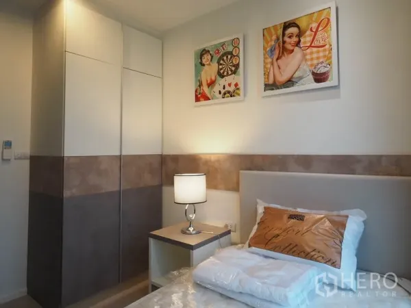 Condominium for rent in Sathon, Bangkok - Compact bedroom featuring built-in wardrobe, bedside table and decorative wall art.