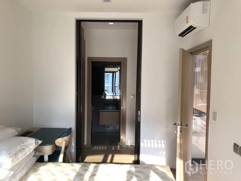 คอนโด ให้เช่าในWatthana, Bangkok - ห้องนอนพร้อมโต๊ะทำงานเล็ก ประตูเชื่อมเข้าห้องน้ำ พื้นไม้โทนอ่อน และเครื่องปรับอากาศ