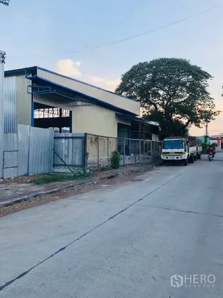 คลังสินค้า ให้เช่าในBang Kapi, Bangkok - มุมมองด้านข้างของโกดังริมถนนเงียบ มีที่จอดรถบรรทุกและต้นไม้ใหญ่