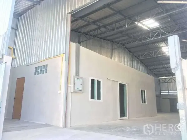 Warehouse for rent in Mueang Samut Prakan, Samut Prakan - Covered loading area with internal office block beneath a steel truss roof.