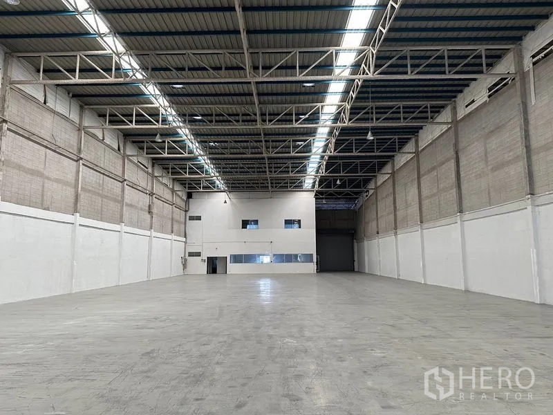 Factory for rent in Si Racha, Chon Buri - Warehouse interior with mezzanine-style office block at the far end of the hall.