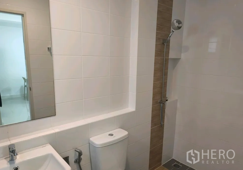 Townhouse for rent in Bang Phli, Samut Prakan - Bathroom with white tiles, sink, toilet and a walk-in shower niche.