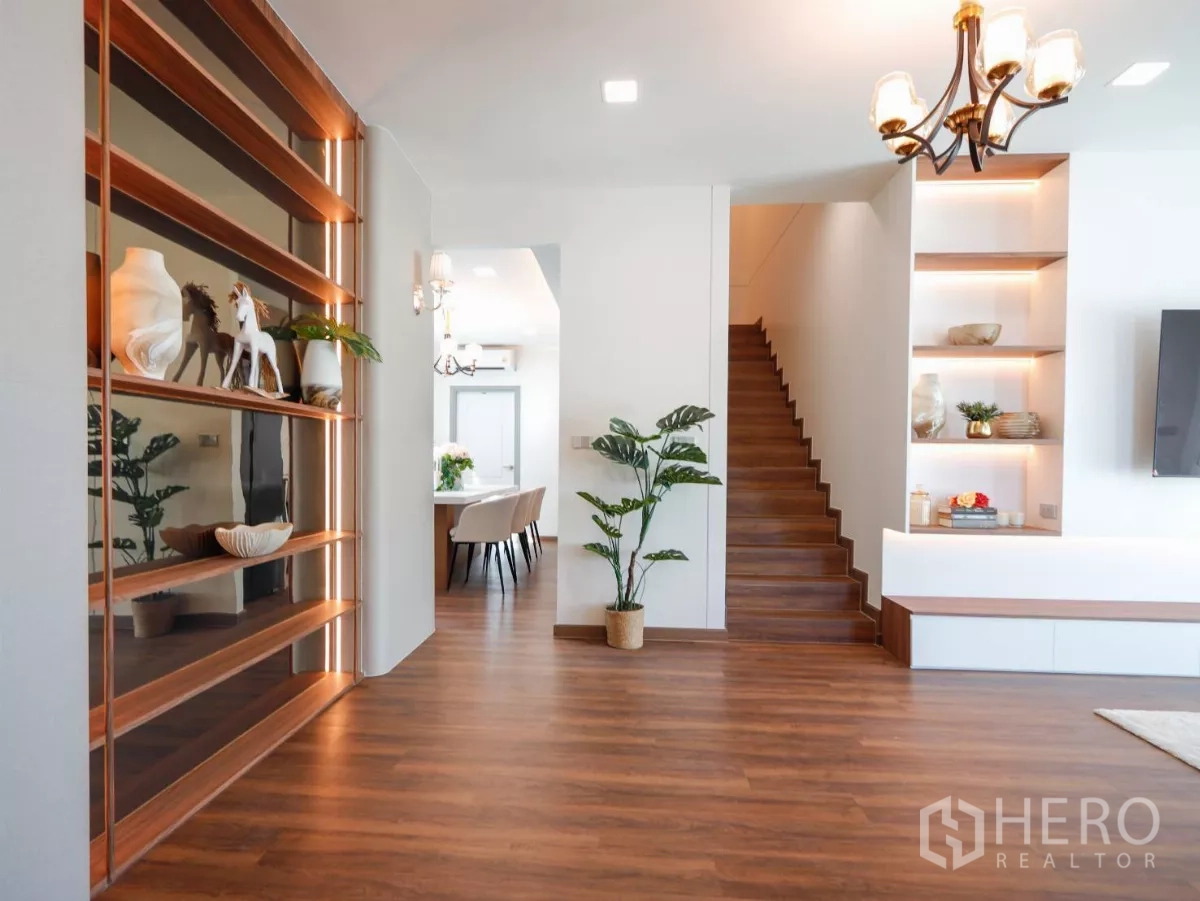 บ้าน ให้เช่าในSattahip, Chon Buri - โถงทางเข้าพร้อมชั้นโชว์ไฟซ่อน ต้นไม้กระถาง และบันไดไม้