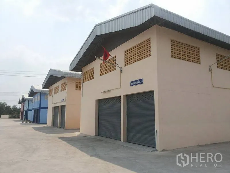 工厂 出租在Lat Lum Kaeo, Pathum Thani - 成排轻工业仓库，卷帘门与通风百叶，配干净的硬化场地