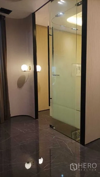 零售空间 出租 - 玻璃围合的私密房间，设壁灯与亮面石纹地面。