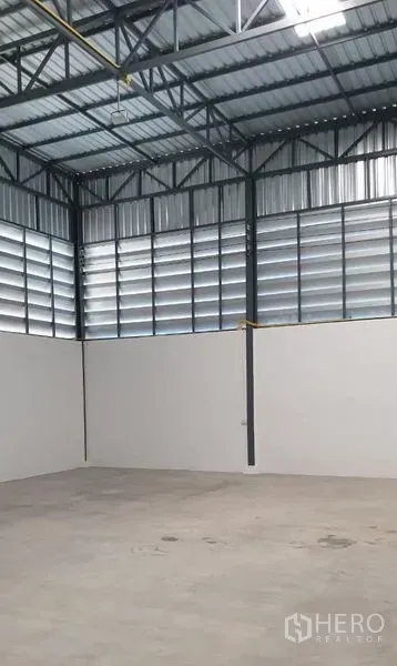 Factory for rent in Lam Luk Ka, Pathum Thani - Warehouse corner showing louvered ventilation panels and steel roof structure.