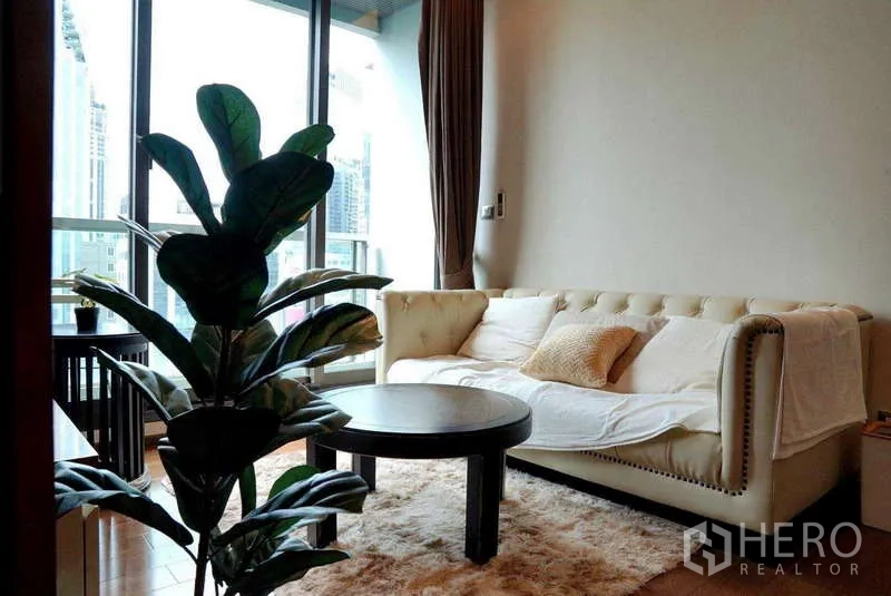 公寓 出租或出售 - 温馨起居区，奶油色沙发与阳台门。