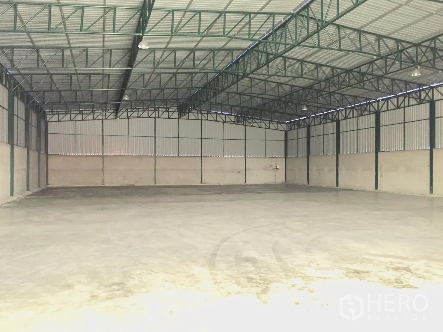 货栈 出租在Si Racha, Chon Buri - 仓库内部，高挑钢桁架屋顶与抛光混凝土地面