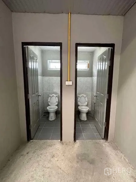 货栈 出租在Mueang Pathum Thani, Pathum Thani - 仓库内并排的两间独立卫生间，铺设瓷砖