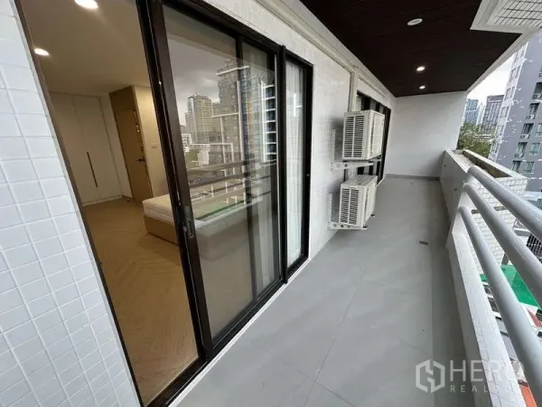 คอนโด ให้เช่าในWatthana, Bangkok - ระเบียงยาวแบบมีหลังคา ประตูกระจกบานเลื่อน เครื่องคอมเพรสเซอร์แอร์ และวิวเมือง