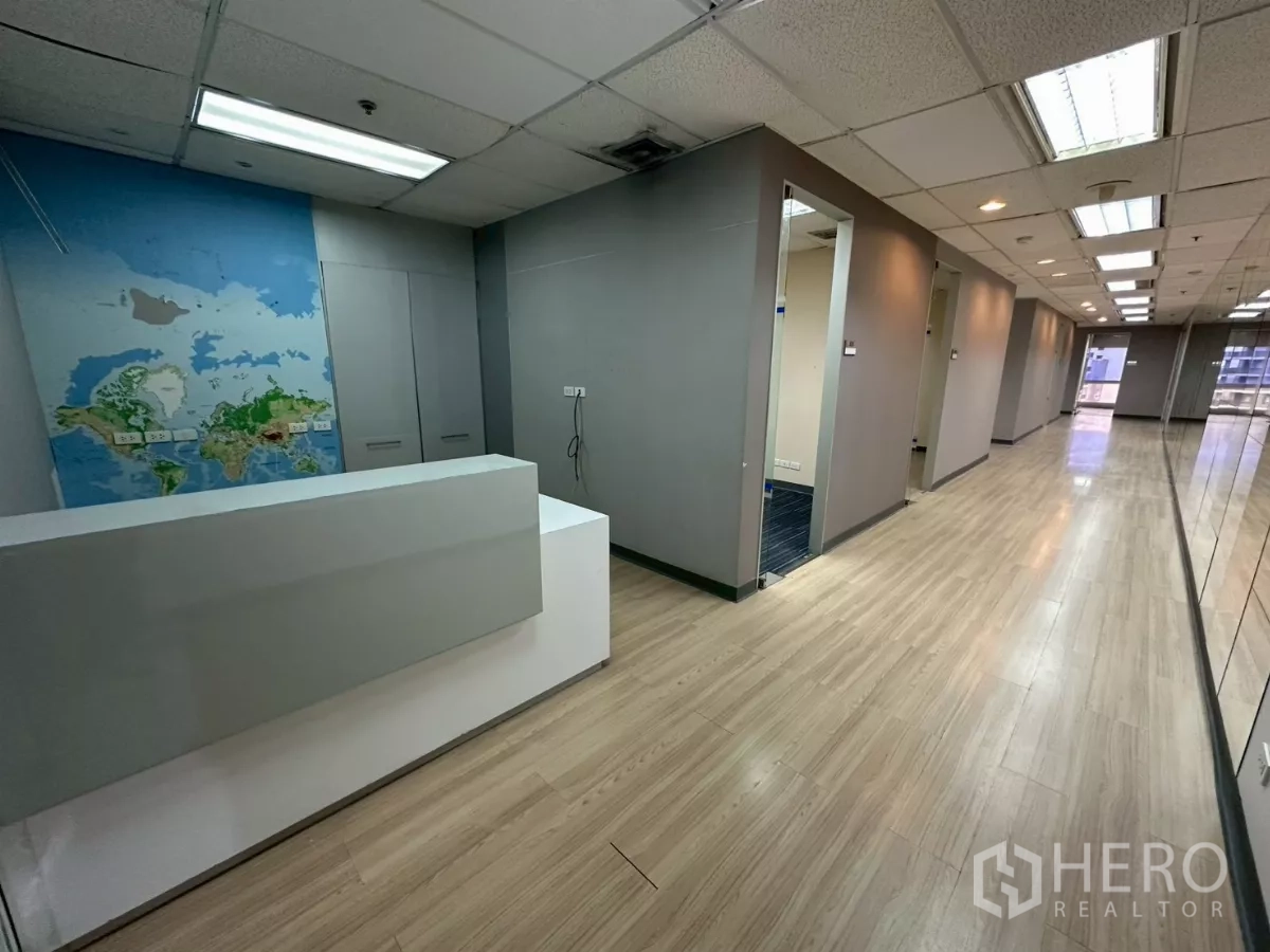 Office Space for rent in Watthana, Bangkok - Reception counter with map mural leading to a corridor lined with private rooms and mirrors.