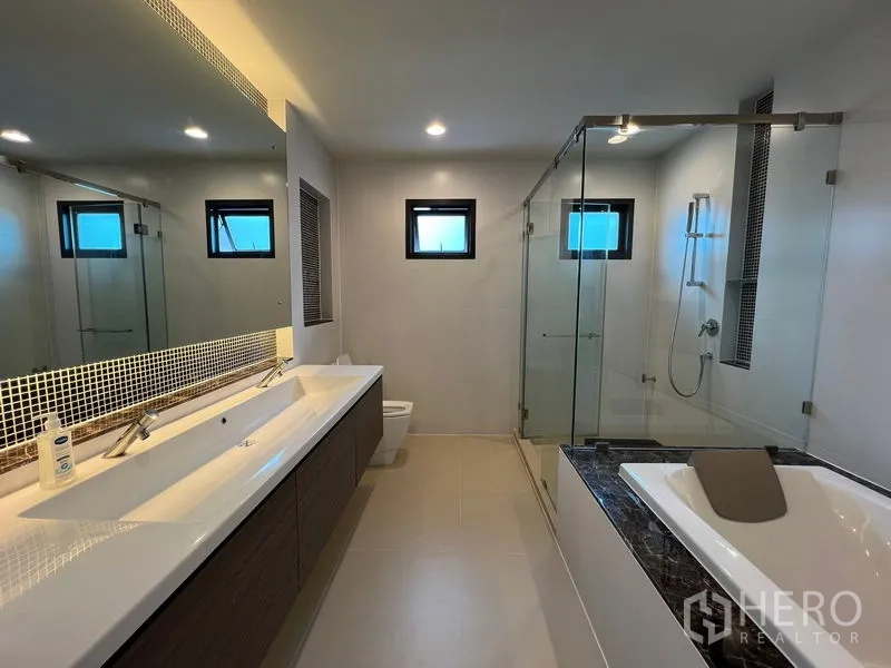 Detached House for rent in Bang Kapi, Bangkok - Master bathroom with double vanity, glass-enclosed shower and bathtub.