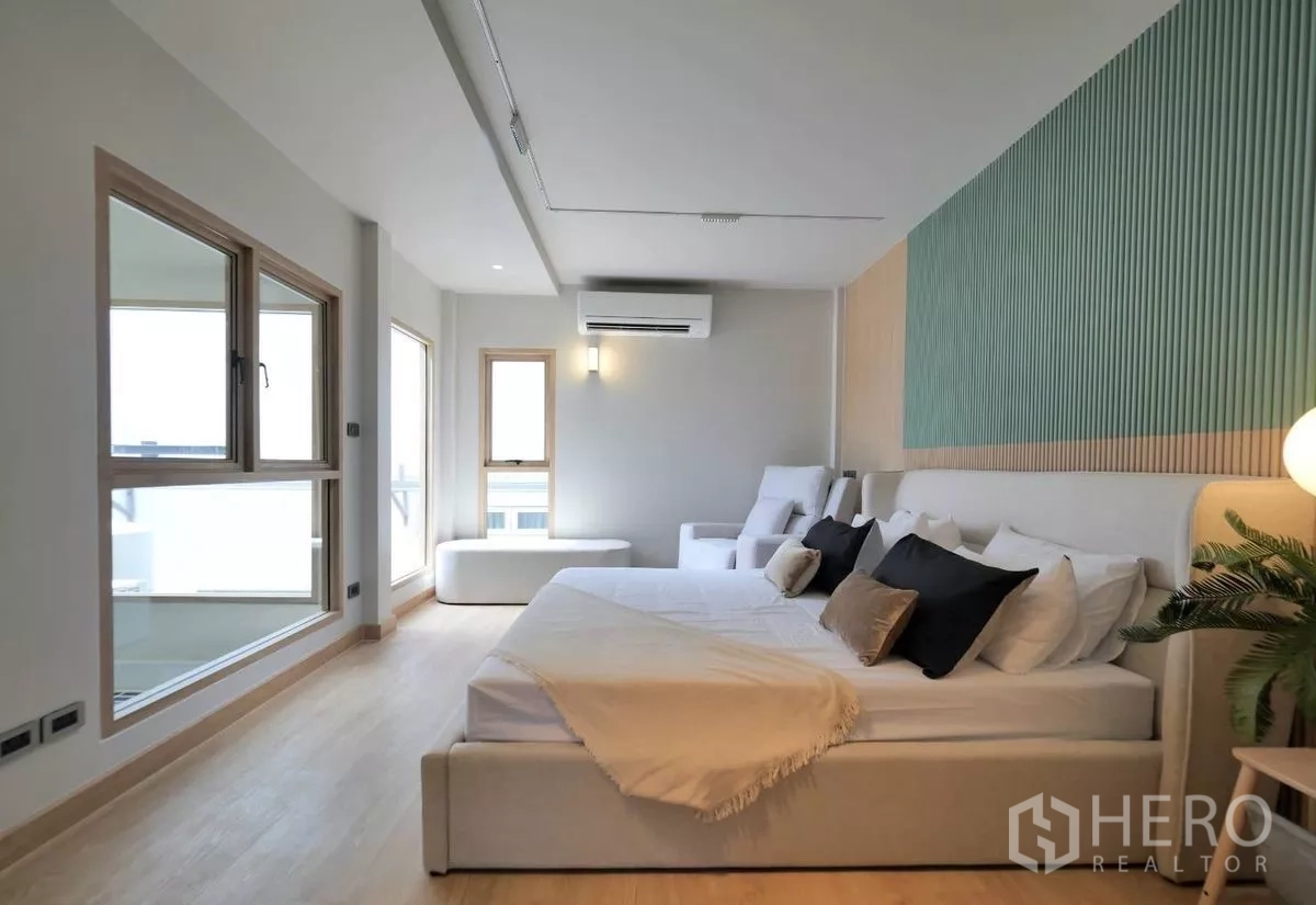 ทาวน์เฮาส์ ให้เช่าในWatthana, Bangkok - ห้องนอนใหญ กว้างขวาง มีมุมนั่งเล่น แอร์ และผนังลอนสีเขียว