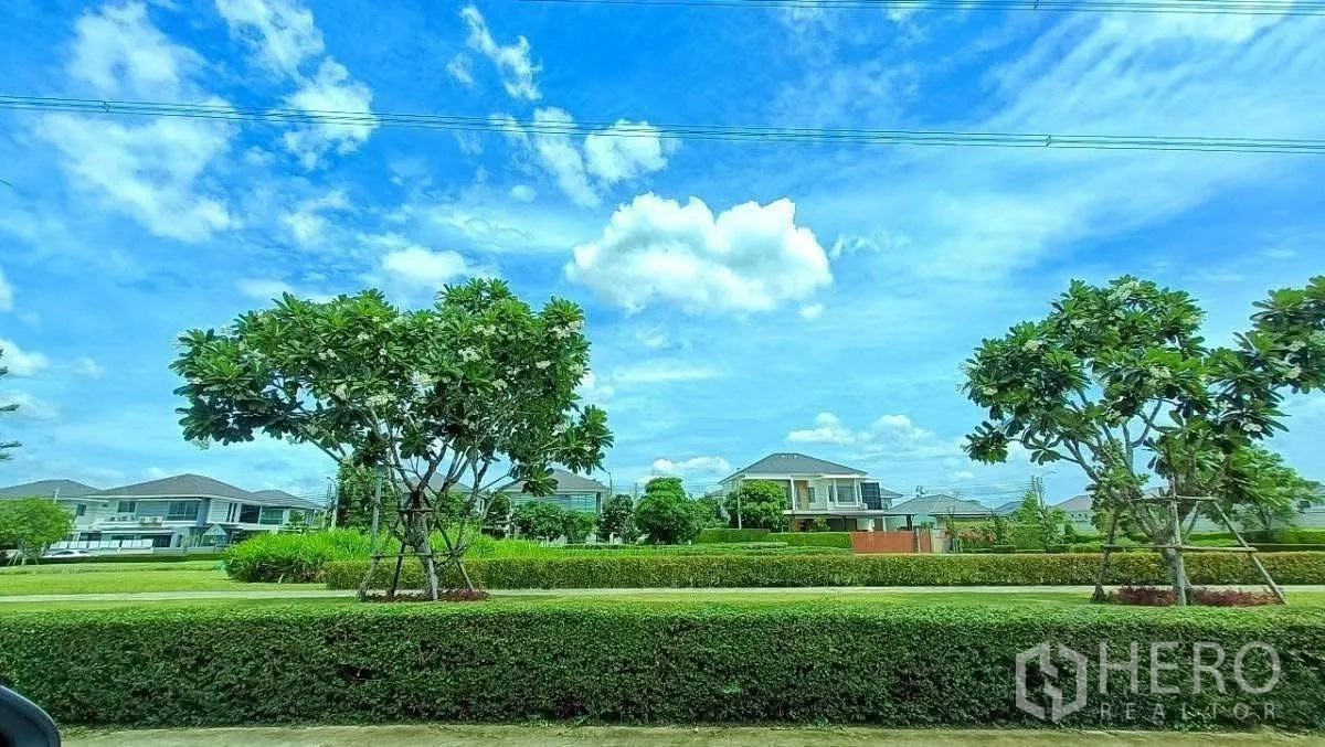 บ้าน ให้เช่าในLat Krabang, Bangkok - พื้นที่สวนส่วนกลางแนวต้นไม้กับบ้านสมัยใหม่ ใต้ท้องฟ้าสีฟ้า