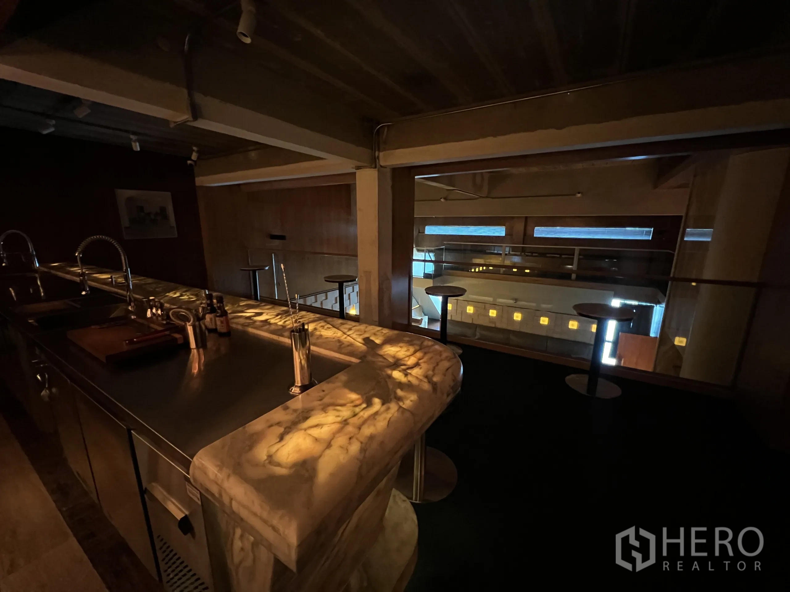 零售空间 出租在Watthana, Bangkok - 从夹层吧台眺望挑高空间与玻璃栏杆。