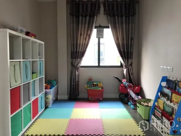 独立式住宅 出租在Saphan Sung, Bangkok - 儿童游戏房，彩色泡沫地垫、收纳格与书架靠窗摆放。