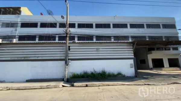 โรงงาน ให้เช่าในBang Phli, Samut Prakan - ด้านหน้าอาคารโรงงานสองชั้นพร้อมช่องระบายอากาศและทางเข้าประตูในเขตบางพลี