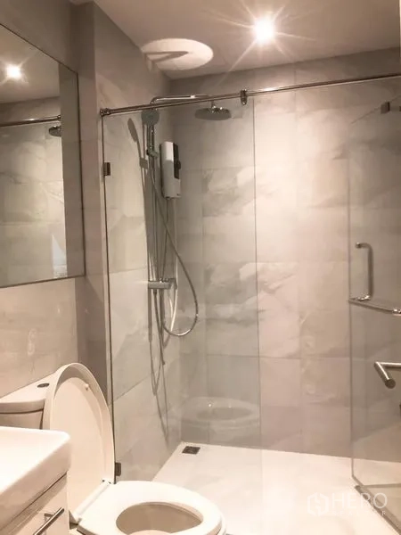 Condominium for rent in Watthana, Bangkok - Modern bathroom with glass-enclosed shower, rain head and toilet.