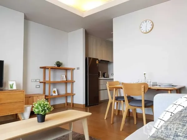 คอนโด ให้เช่าในKhlong Toei, Bangkok - พื้นที่นั่งเล่นแบบเปิดโล่ง เฟอร์นิเจอร์ไม้สีอ่อน ชุดทานอาหาร และครัวขนาดกะทัดรัดพร้อมตู้เย็น