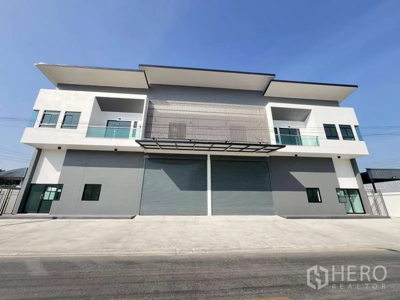 คลังสินค้า ให้เช่าหรือขาย - ด้านหน้าอาคารโกดังแบบสมมาตร มีประตูม้วนสามบานและกันสาดยื่น