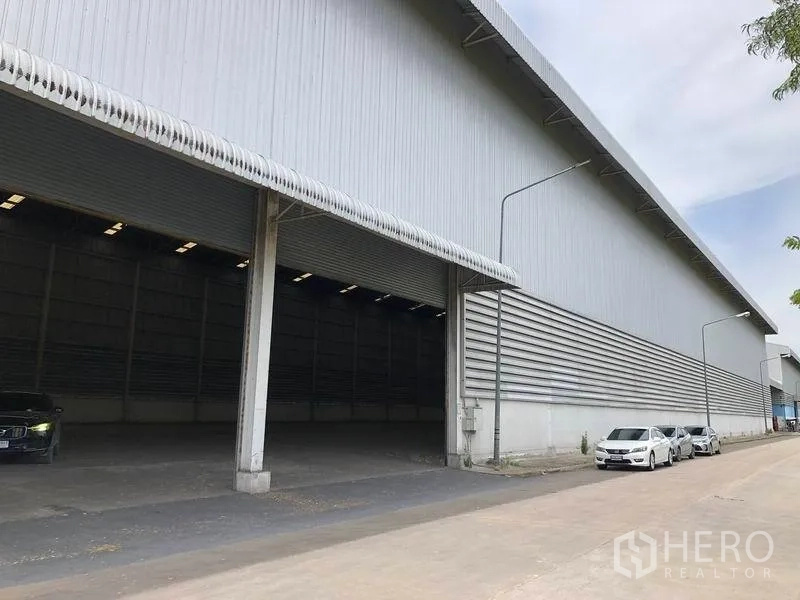 货栈 出租在Phra Nakhon Si Ayutthaya - 仓库立面设有带雨棚的装卸月台，车道宽阔便于卡车进出。