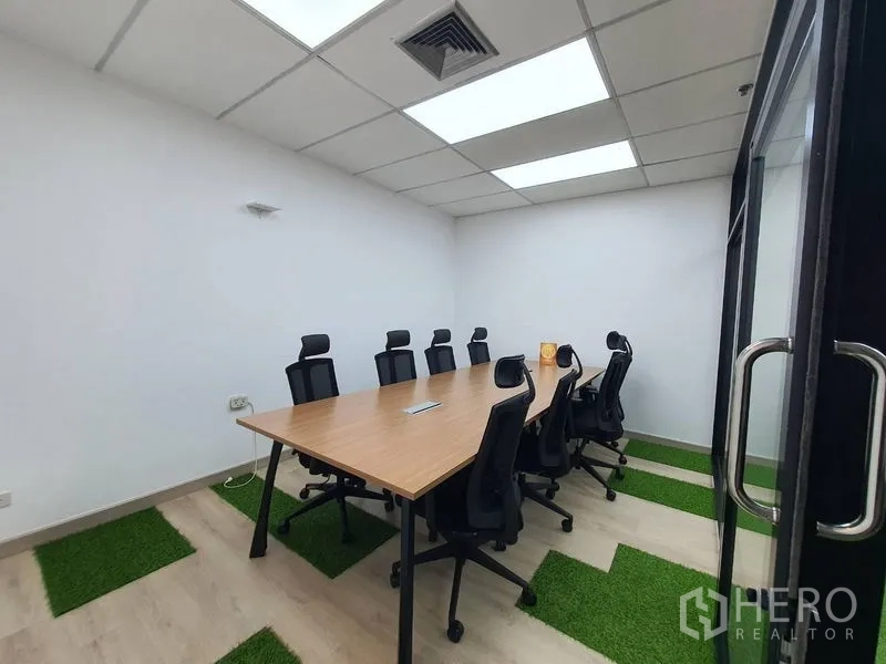 办公空间 出租 - 玻璃门会议室，可容纳8人，顶置灯盘，长方形桌与草坪装饰地面。