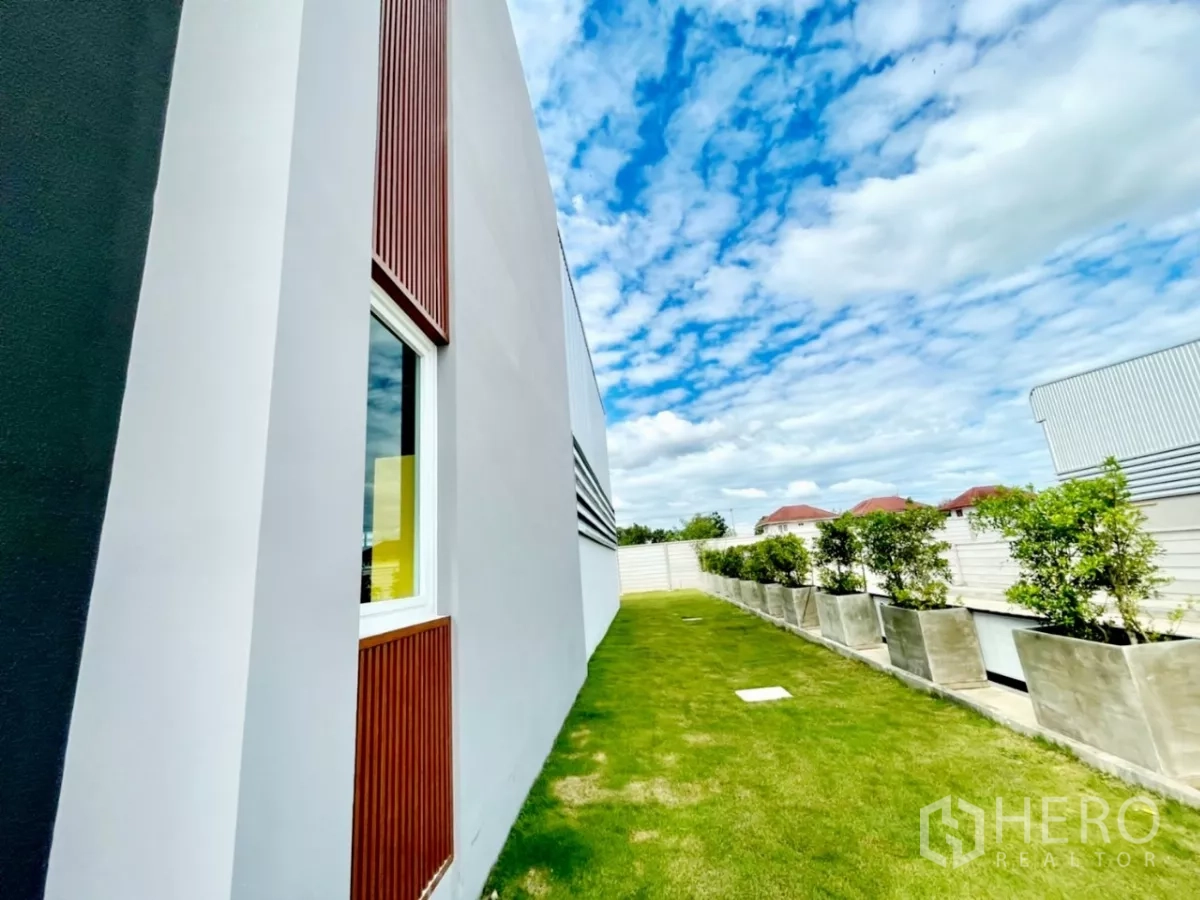 คลังสินค้า ขายในLam Luk Ka, Pathum Thani - ด้านข้างออฟฟิศและโกดัง พร้อมสนามหญ้า กระถางต้นไม้ และกำแพงรั้ว