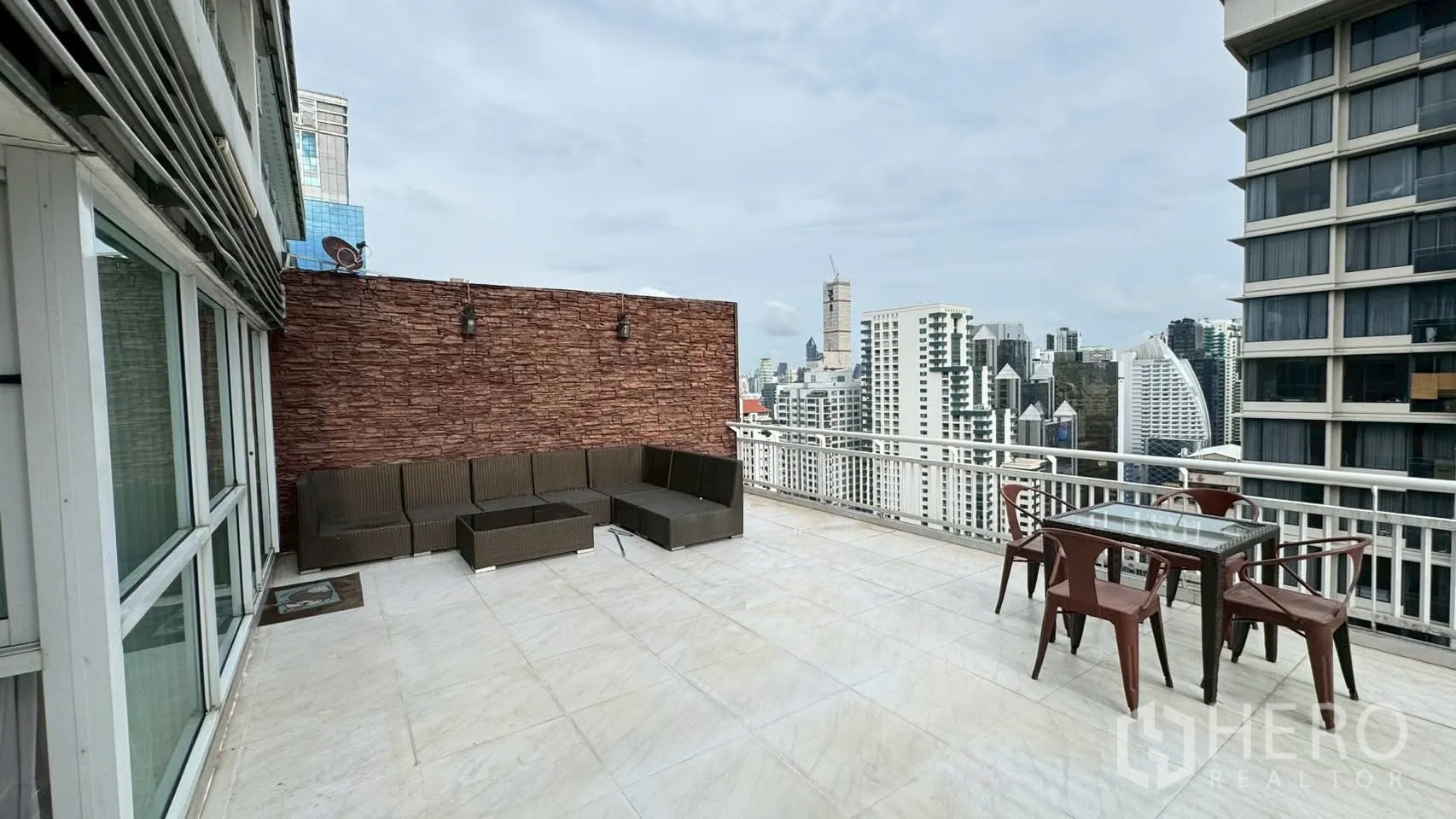 Condominium for rent or sale in Watthana, Bangkok - Expansive private terrace with outdoor sofa set and open skyline views.