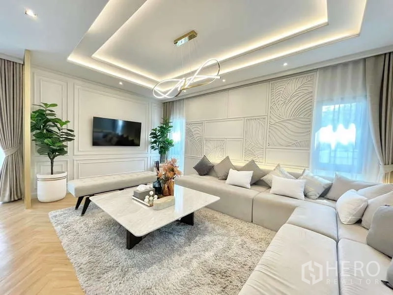 Detached House for rent in Bang Phli, Samut Prakan - Bright lounge with TV wall, plants and marble coffee table on a plush rug.