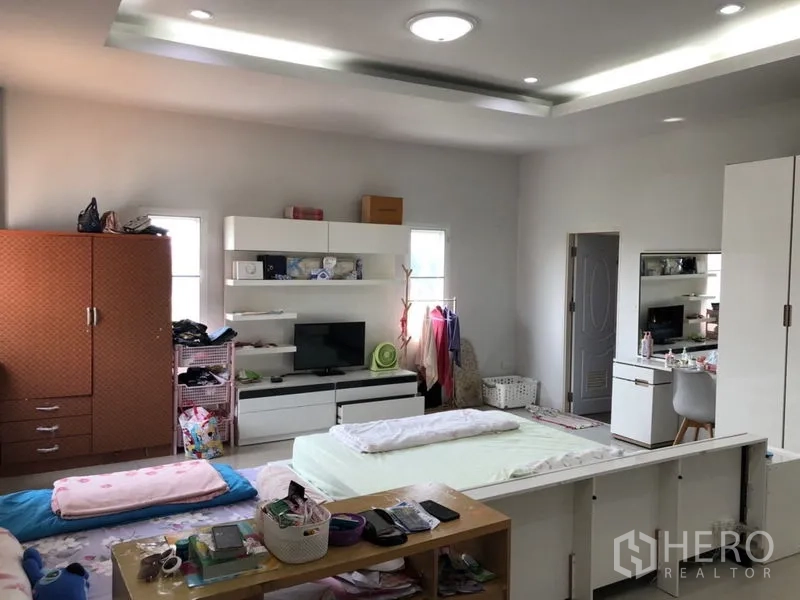 บ้าน ขายในLam Luk Ka, Pathum Thani - ห้องนอนพร้อมชั้นวางบิวท์อิน โต๊ะเครื่องแป้ง และเฟอร์นิเจอร์สีขาว