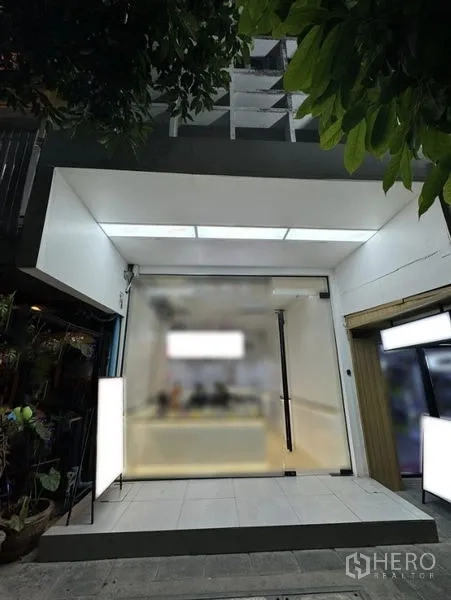 อาคารพาณิชย์ ให้เช่าในKhlong Toei, Bangkok - ด้านหน้าอาคารพาณิชย์กระจกสมัยใหม่ มีไฟส่องสว่างและทางเข้า