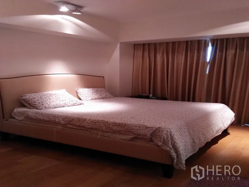Condominium for rent in Sathon, Bangkok - Master bedroom with king-size bed, curtains and recessed ceiling lights.