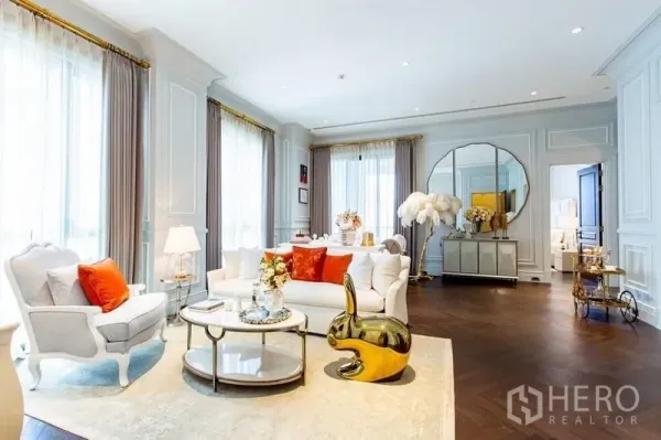 Condominium for sale in Pathum Wan, Bangkok - Elegant lounge with round mirror, gold decor and city-light windows in a 132 sqm Bangkok condominium.