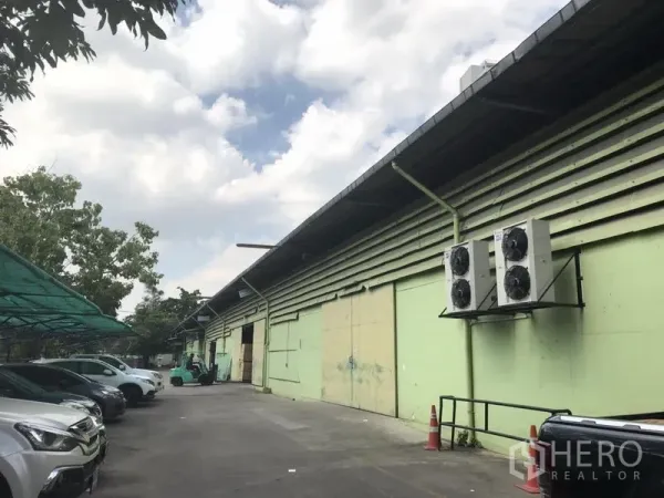 คลังสินค้า ให้เช่าในKhlong Toei, Bangkok - ด้านหน้าโกดังสีเขียว ทางรถกว้าง มีที่จอดรถมีหลังคา และชุดคอยล์ร้อนภายนอก