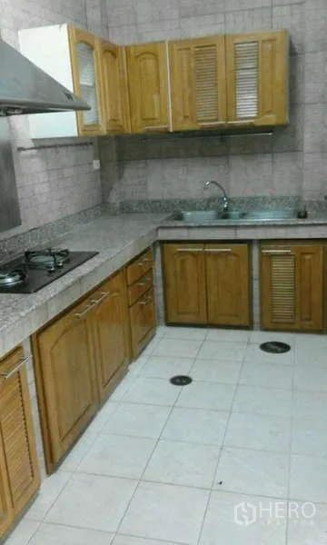 ทาวน์เฮาส์ ให้เช่าในSuan Luang, Bangkok - ครัวรูปตัวแอล ตู้ไม้ เคาน์เตอร์หินแกรนิต เตาแก๊ส เครื่องดูดควัน และอ่างล้างจานสเตนเลส