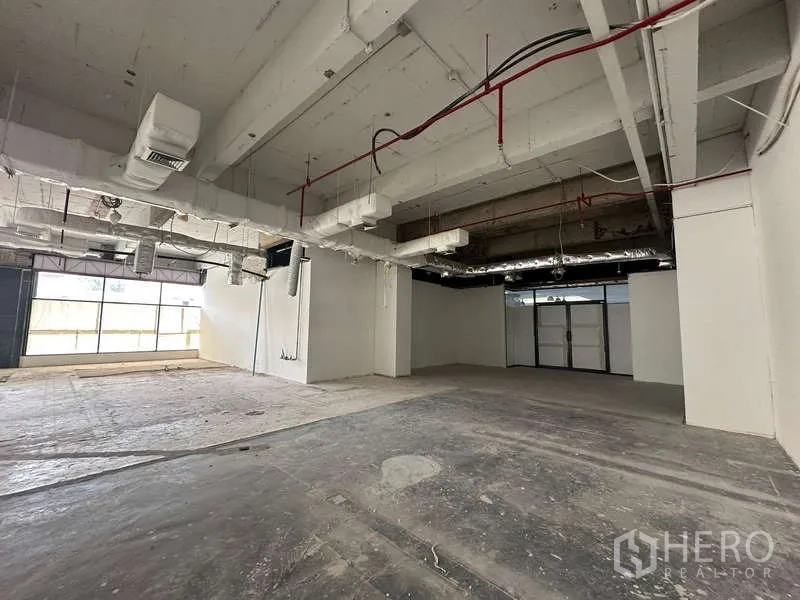 办公空间 出租 - 宽敞未装修办公室，混凝土地面、整面采光窗与管道空调系统。