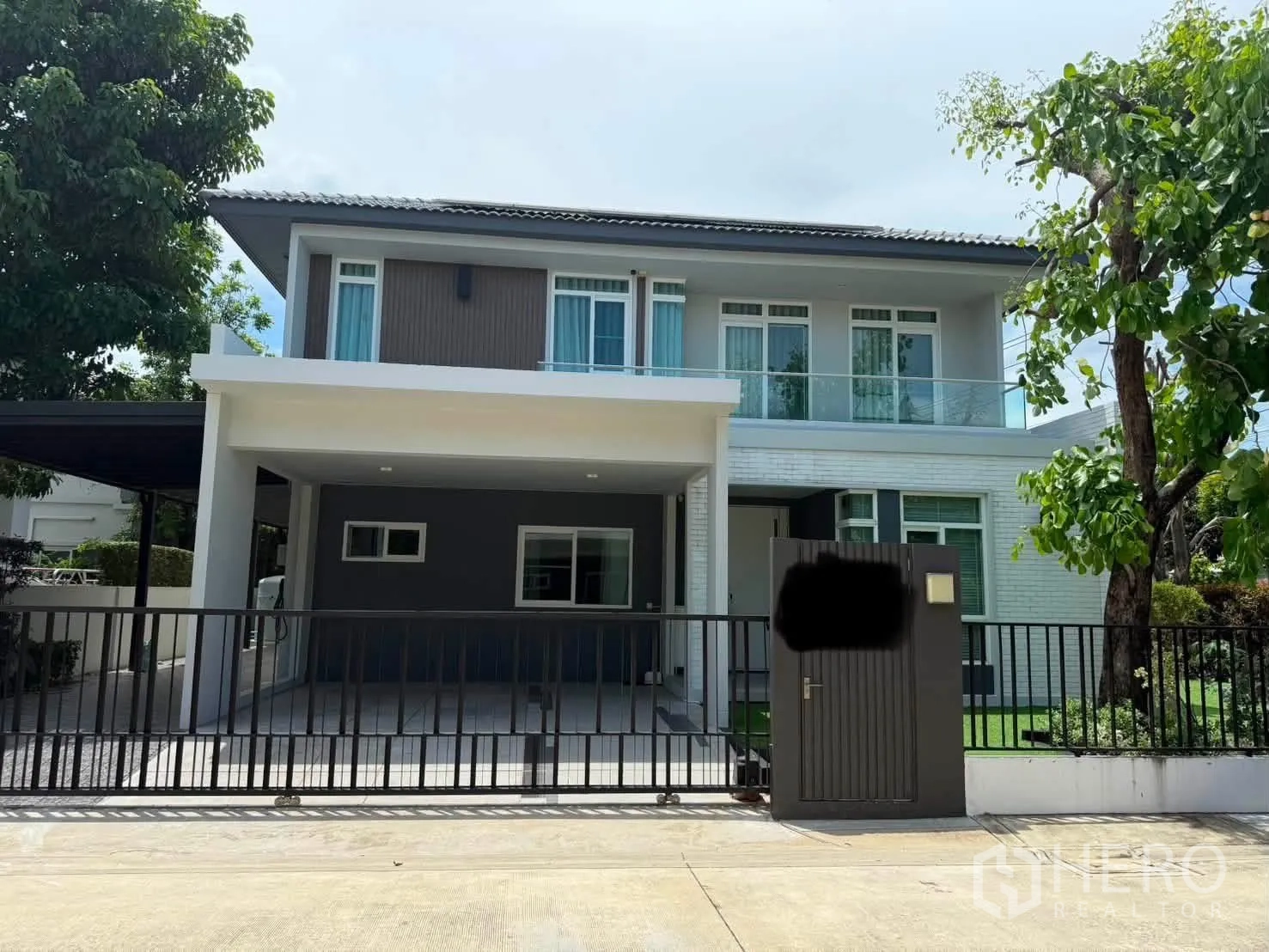 Detached House for rent in Bang Phli, Samut Prakan - Modern two-storey house facade with balcony and gated entrance.