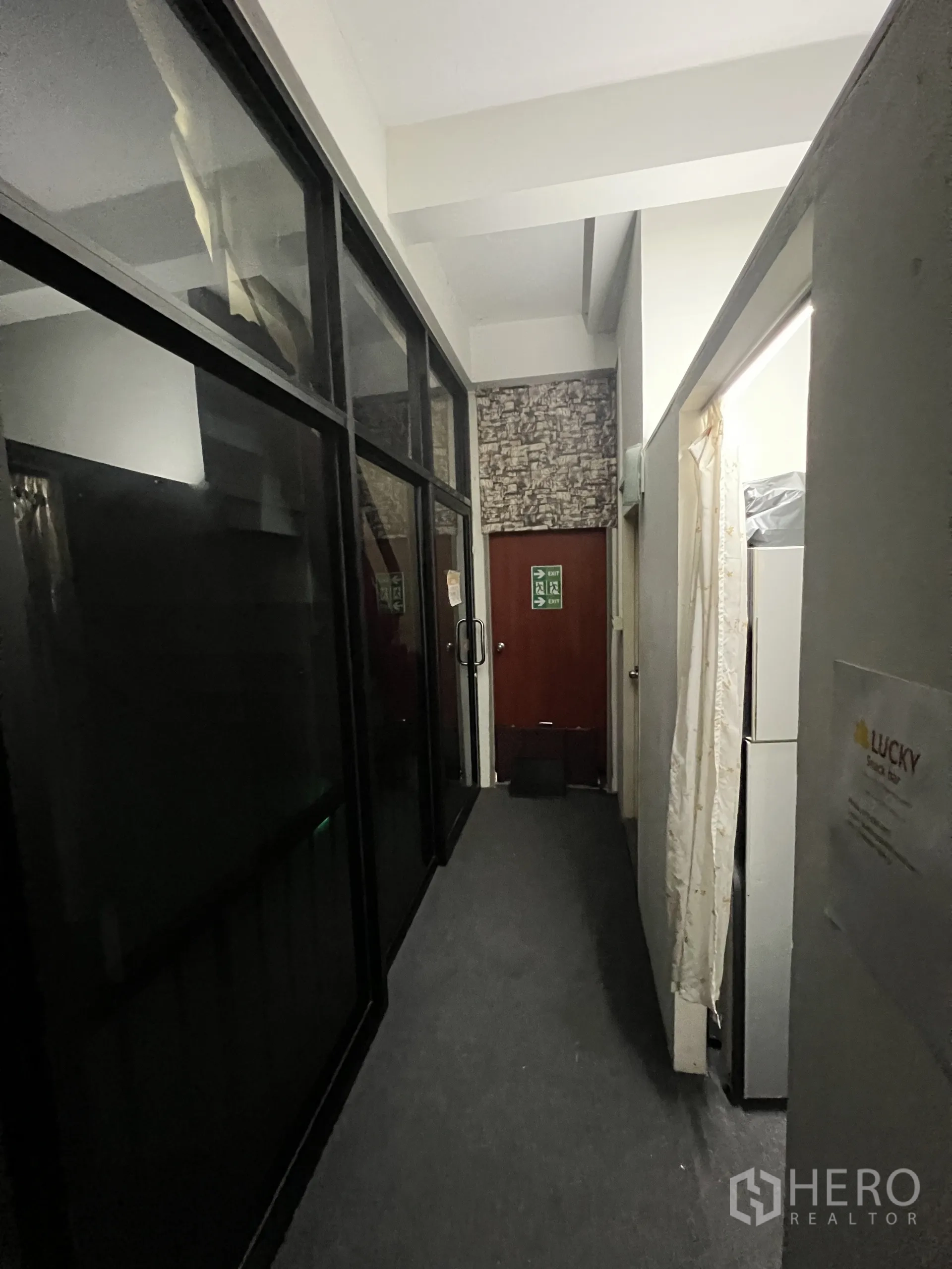 店屋 出租在Khlong Toei, Bangkok - 铺地毯的走廊，黑色玻璃隔墙通向后门。