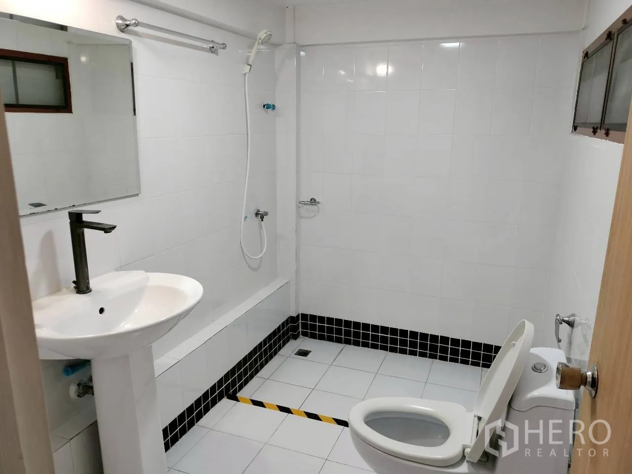 Home Office for rent in Watthana, Bangkok - White-tiled bathroom with shower, toilet, and pedestal sink.