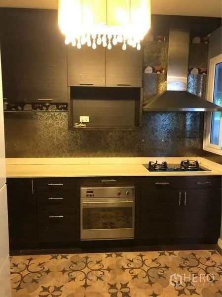 บ้าน ให้เช่าหรือขายในPrawet, Bangkok - ห้องครัวบิลท์อิน ตู้สีเข้ม เตาแก๊ส เตาอบ เครื่องดูดควัน และพื้นลายวินเทจ