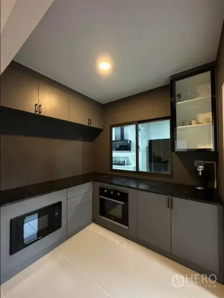 บ้าน ให้เช่าหรือขายในKhlong Toei, Bangkok - ครัวตะวันตกทรงตัวแอล ท็อปหินสีดำ มีเตาอบ ไมโครเวฟ และตู้เก็บของครบ.