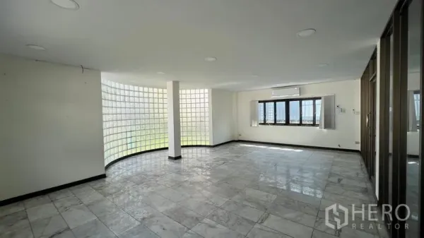 Warehouse for rent in Thanyaburi, Pathum Thani - Bright office interior with curved glass-block wall, tiled flooring, and windows for natural light.