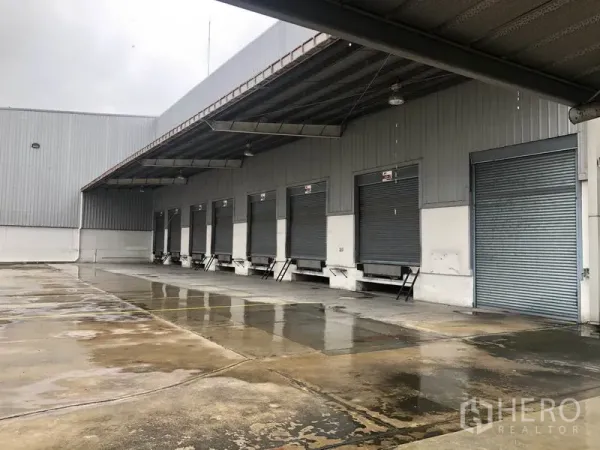 工厂 出租在Phra Nakhon Si Ayutthaya - 带顶装卸平台，配有多组登车桥与金属卷帘门，适合拖车作业。